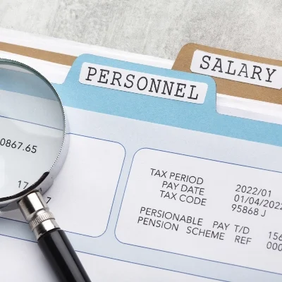 A magnifying glass inspects payroll documents by folders marked "Personnel" and "Salary," symbolizing thorough private investigation.