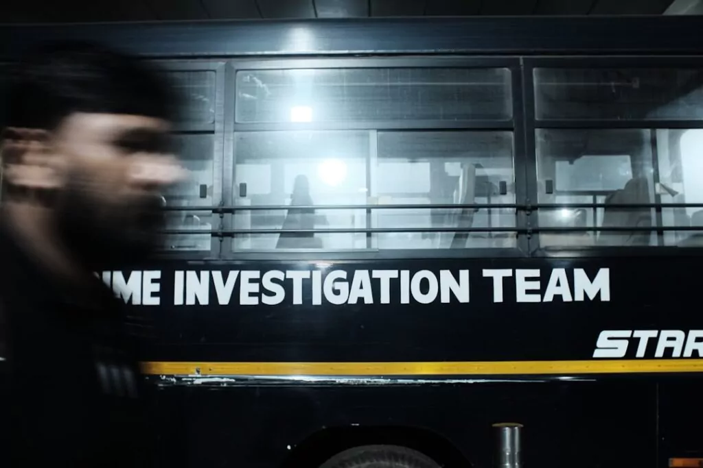 A man walks by a "CRIME INVESTIGATION TEAM" vehicle, highlighting expert private investigators at work behind its windows.